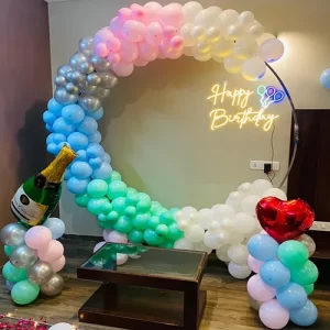 Pastel rainbow circular balloon arch birthday decoration with Happy Birthday neon sign in Indore