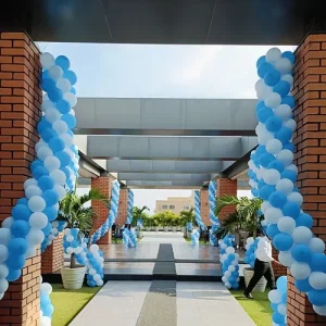 Birthday balloon decoration with blue and white spiral balloon columns at a pergola entrance in Indore