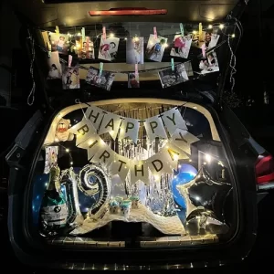 19th birthday car trunk decoration with gold foil balloons, fairy light photo display and silver curtain backdrop in Indore
