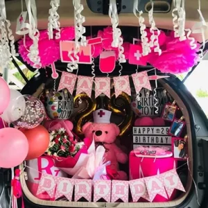 Pink nurse theme birthday surprise car trunk decoration with Happy Birthday 29 foil balloons, pom poms and streamers in Indore