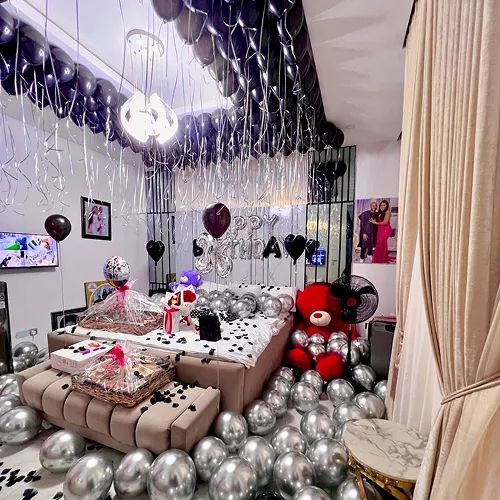 Black silver birthday room decoration with teddy bear gift hamper black ceiling balloons and chrome silver floor balloons Indore