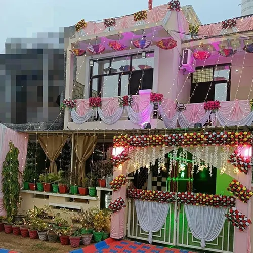 Pink and white house decoration with fairy lights and colourful umbrellas on two-storey building