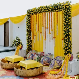 Premium haldi backdrop decoration with designer flower wall gold frame and luxury seating in Indore