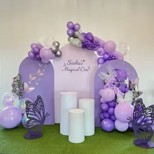 Purple butterfly first birthday theme decoration with balloon arch and butterfly cutouts in Indore