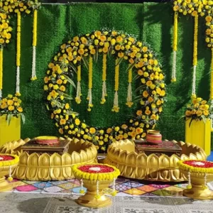 Royal gold haldi theme decoration with golden drapes marigold flowers and brass decor in Indore